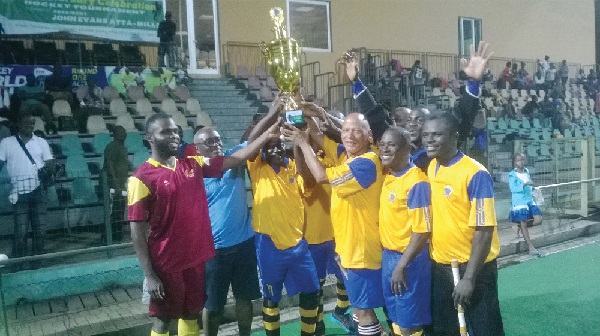 Sam Kofi Atta Mills (left) presenting a trophy to K.N. Owusu XI team