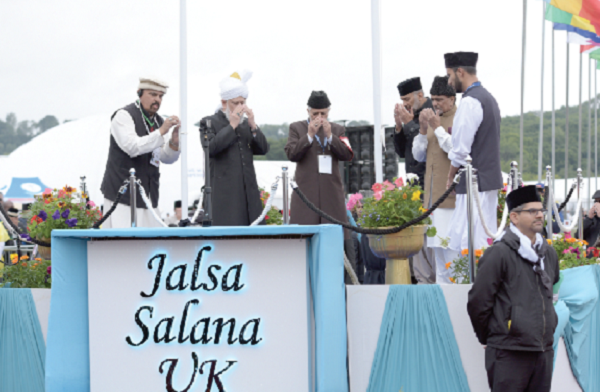 His Holiness Masroor Ahmad  (2nd left) leading prayers after hoisting the UK and Ahmadiyya flags to  symbolically mark the opening of the 2017 Jalsa Salana