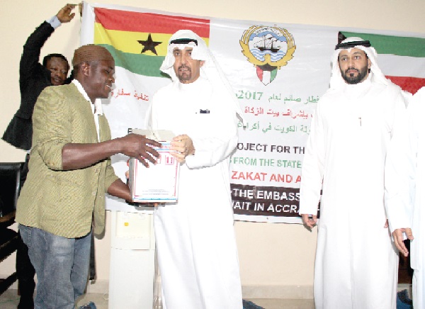 Mohammed Hussein Alfailawi (second   left), Kuwaiti Ambassador to Ghana, presenting some items to Sulley   Rahaman,  a beneficiary. Picture: Anita Nyarko-Yirenkyi
