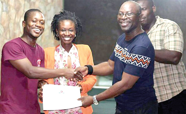  Mr. Tachie-Menson (right) presents an award to Nathaniel Somuah (left) Manager of Tesano Spinners
