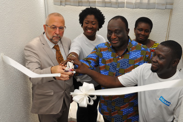 Mr Alan Kyerematen (3rd left) being assisted by Mr Alex Deprez (left), USAID Mission Director, Mr Gregory Kankoh (right), President of AGAM, and some invited guests to cut the tape to declare the offices of  AGAM officially opened