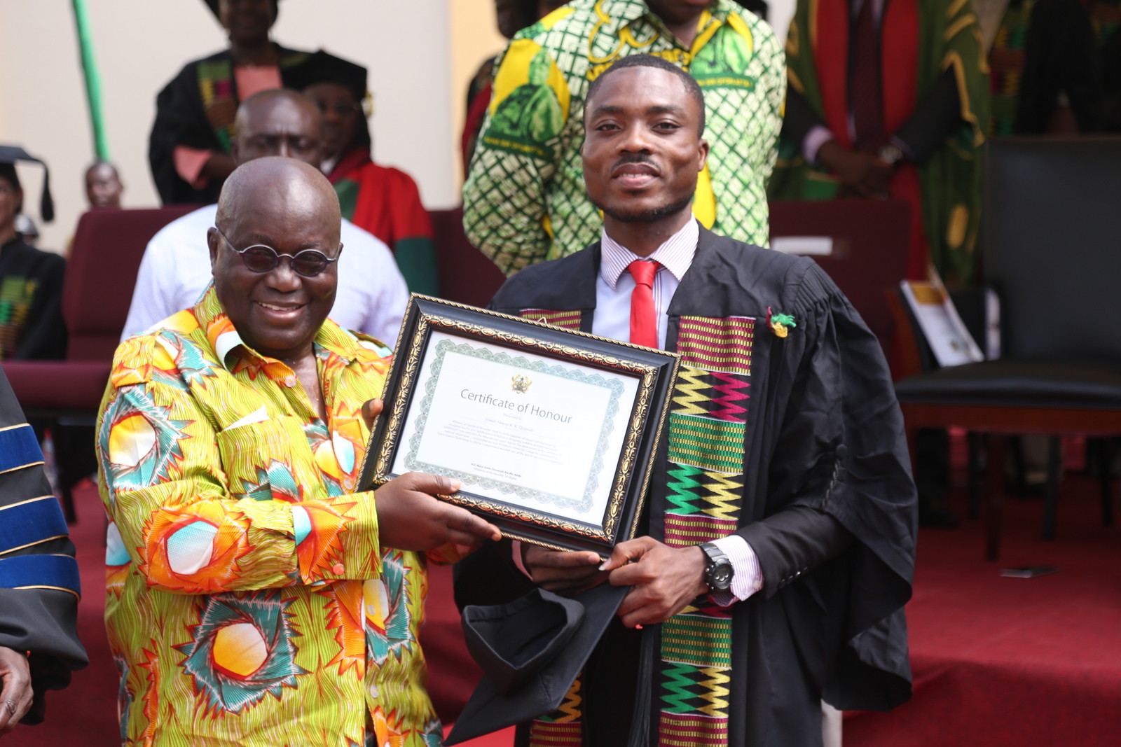 President Akufo-Addo presenting a citation to one of the students responsible for the launch of Ghana's first satellite into space