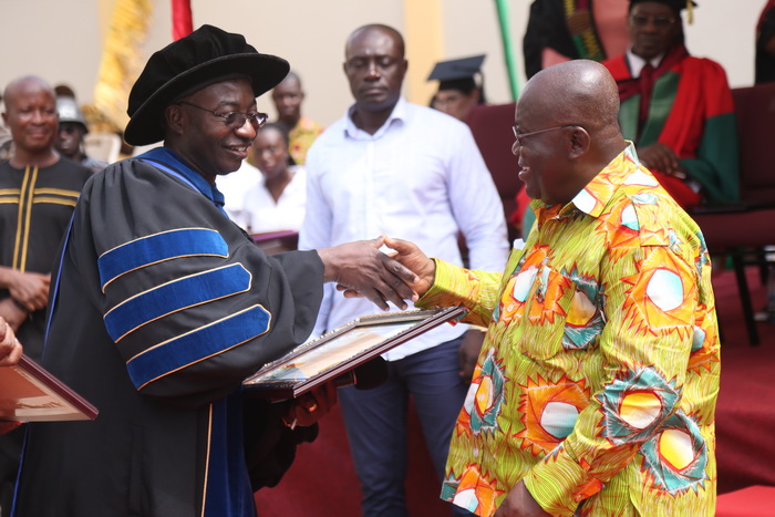 Dr Samuel Donkor (left), Founder, All Nation University College, presenting a citation to President Akufo-Addo at the congregation ceremony in Koforidua.