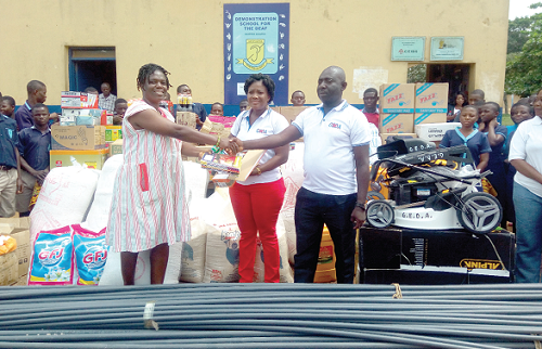 Mr Koranteng Asiamah (right), Chairman, GEDA, presenting the items to Mrs Trudy Akusika Segbefia, while Mrs Fortune Kissi (middle), GEDA member looks on