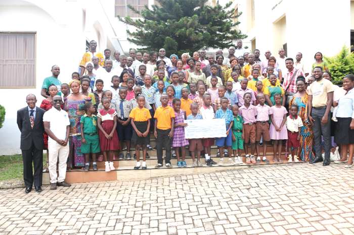 Mr Vincent Amponsah (2nd left), Head of Business, Sinapi Aba Savings and Loans, some parents and heads of the selected schools with some of the beneficiaries. Those with them include Rev. Kofi Sarpong (left), Proprietor, New Life Christian Academy