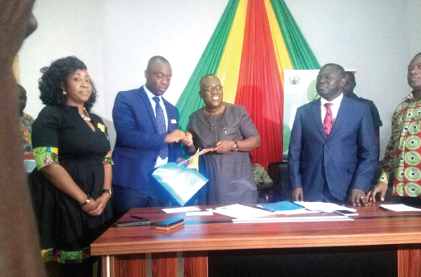 The Chief Executive Officer of the Forestry Commission, Mr Kwadwo  Owusu-Afriyie (2nd right), exchanging the signed agreement with the Chief Executive Offier of the National Youth Employment Agency, Mr Justine Kodua Agyeman (2nd left) while others including the Deputy Minister of Lands and Natural Resources, Mr Benito Owusu Bio look on