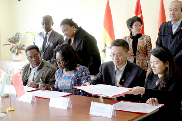 Mrs Rebecca Akufo-Addo (standing 2nd left) looks on while Mrs Laryea (2nd left seated) signs on behalf of the Rebecca Foundation while Mr Wang Xiaoguang (2nd right seated), the Director General, Education and Sports Bureau of the Licang District in China, signs for the school