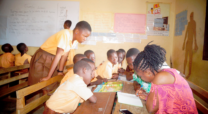 A teacher taking some pupils through reading lessons