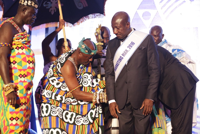 Nana Bonsu Ayepe II (2nd left), Kwahu Pepeasehene, decorating Mr Ebenezer Twum Asante (right) with the Marketing Man of the Year 2016 award at the CIMG 28th National Performance Awards at the Banquet Hall, State House, Accra
