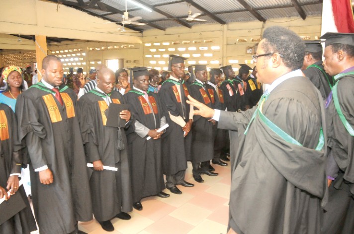 The principal and officials of the college praying for the graduating pastors.