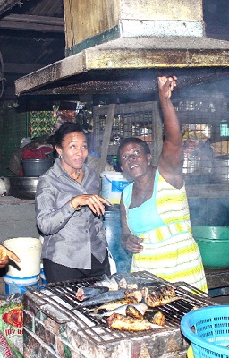 Madam Tetteh (right) the queen mother of the market showing Dr Agyeman-Rawlings (left) how the chimney sucks up smoke into the atmosphere. 