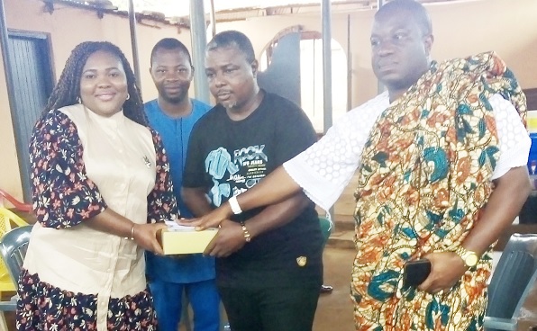 Jennifer Dede Adjabeng (left), MCE for La Nkwantanang-Madina, presenting an envelope and traditional drink to Nii Manle Dzahaa (right), the Chief of Teiman