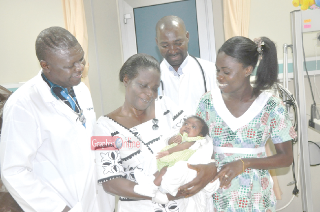  Delighted Anti Yaa Gyimah cuddling her grandchild during a review visit to the Paediatric Intensive Care Unit (PICU) at the Komfo Anokye Teaching Hospital (KATH). Those looking on are Dr John Adabie (left), Head of PICU, Dr Eric Broni, and Mrs Caroline Essel (right), a Critical Care Nurse. Pictures: EMMANUEL BAAH