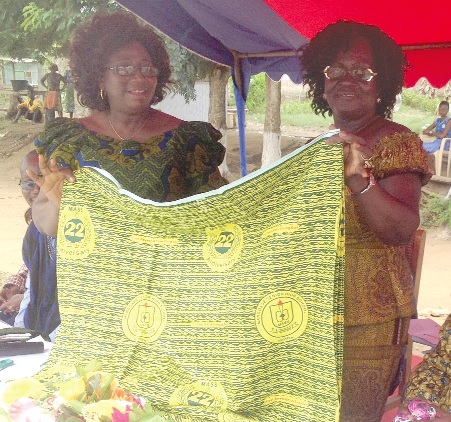Ms Kandilige (left) being assisted by a member of the board  of the school  to unveil the new cloth.
