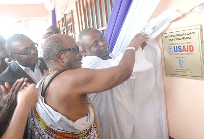   Nii Kwame Perbi III, Chief of Samsam-Odumase, being assisted by Mr Emmanuel Nii Okai (right), MP for Amasaman, to unveil a plaque, to inaugurate the ICT centre at Samsam-Odumase. Looking on include Mr Ebenezer Nii Armah Tackie (left), MCE of Amasaman