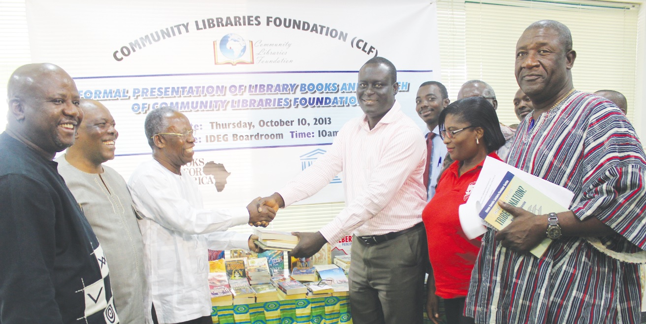 Mr Kojo Yankah (3rd left),  presenting a set of story books to Mr Guy Amarteifio (3rd right), Library Connectivity Project Coordinator, Ghana Library Authority.