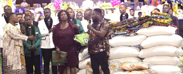 Apostle Philemon Okoh Agyeman (left), Founder and Leader of Living Yahweh 7th Day Assembly, presenting some bags of rice to the beneficiaries