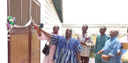 Mami Dufie Ofori (left) being assisted to cut a tape to officially hand over the facility to the hospital