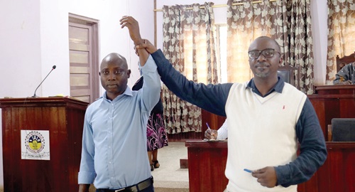 Kofi Annan Noonoo, Birim Central Municipal Electoral Officer, raising the hand of Castro Asumadu-Addae as the new presiding member for the municipal assembly