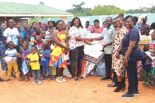 Gustav Anim-Mantey (4th from right), Junior High School Headmaster, VPCS, presenting some items to Nana Ama Owusu (2nd from left), Executive Director, Potters Village Ghana, Dodowa. With them are Michael Amponsah (3rd from right), Outreach Committee Chair, VPCS, other dignitaries and schoolchildren at the ceremony. Picture: ESTHER ADJORKOR ADJEI