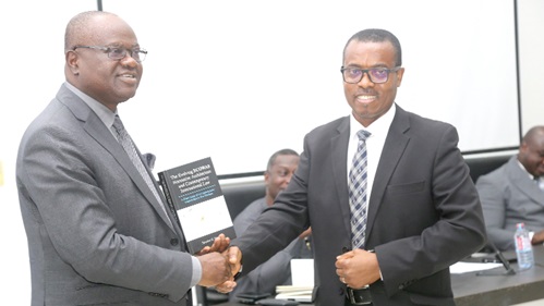  Kwaku Ampratwum-Sarpong (left), a Deputy Minister of Foreign Affairs and Regional Integration, commending Dr Senalo Kwabla Yawlui (right), author of the book, in Accra. Picture: SAMUEL TEI ADANO