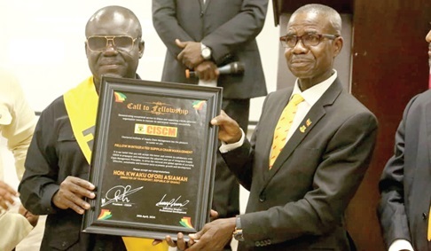 Kwaku Ofori Asiamah (left), Minister of Transport,  being presented with a plaque by  Col. Emmnauel Darquah (retd), a member of the Governing Council of CISCM