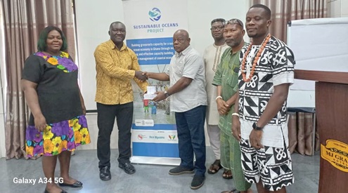 Osei-Akoto Nyantakyi (2nd from left), Programmes Officer, EJF, handing over the identification cards to Nana Jojo Solomon (4th from right) President, GNCFC