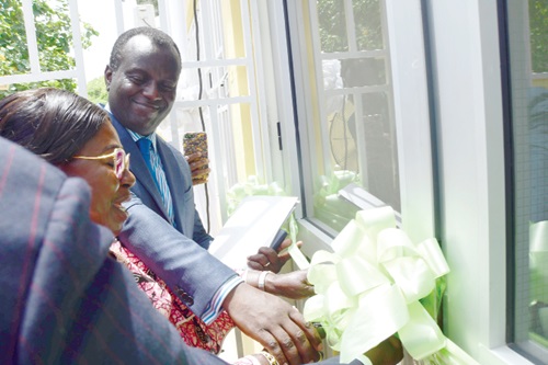 Akosua Frema Osei-Opare, the Chief of Staff, cutting a tape to inaugurate the new offices of the Real Estate Agency Council (right). With her is Kojo Addo-Kufuor, the Board chair, REAC.