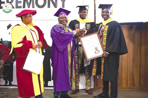 Joseph Cudjoe (2nd from left), Minister of Public Enterprises, presenting a citation to Emmanuel Gyadu (right), the valedictorian