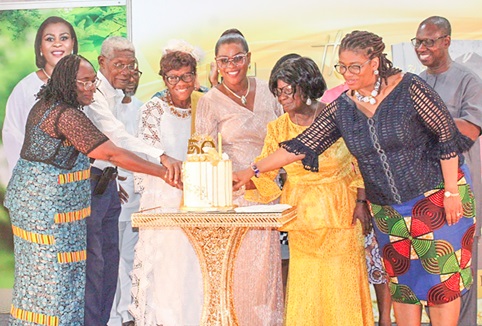  Dr Mrs Linda Narh(arrowed), cutting her birthday cake with relatives and dignitaries presents at the book launch and birthday celebration.