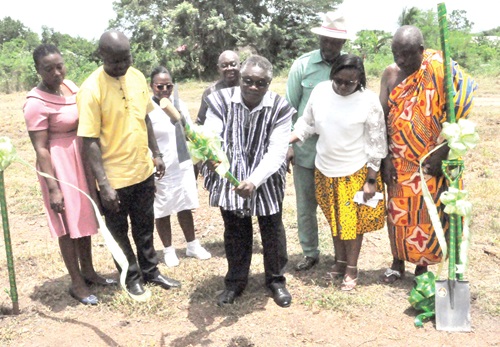  Dr Mark Amexo (in smock), member of the Governing Council of UHAS, cutting the sod for the commencement of the project, while some stakeholders look on