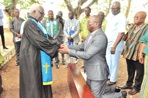 Rev. S.K. Tettey (left), Head of Administration and Human Resource, EPCG, taking Benjamin Yao Dei through the induction rites while other stakeholders look on