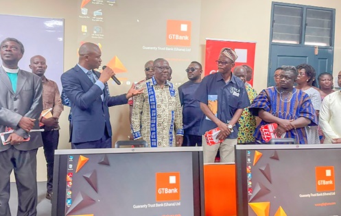 Iris Richter-Addo  (2nd from left), GM, General Internal Services, GTBank briefing Samuel Otopah Ntow (3rd from left), Municipal Director of Education, Adoagyiri, and other officials on the furnished ICT lab