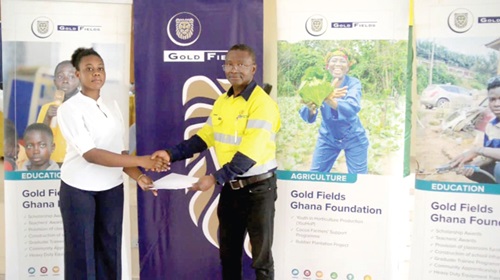 acinta Tandoh (left), a beneficiary, receiving her certificate from Robert Siaw, Regional Manager, Community Relations, Gold Fields Ghana