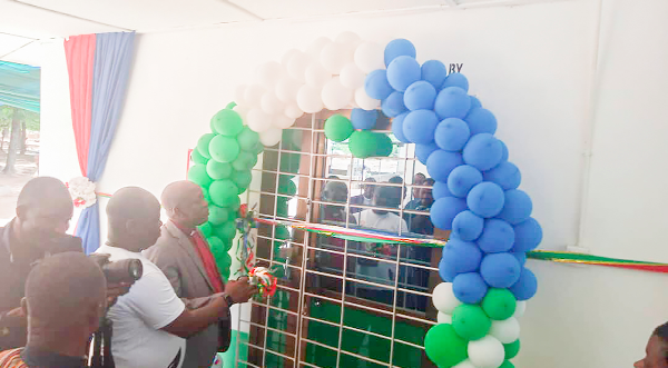 Rev. James Kwame Awuni (in suit), Chairman, Presbyterian Health Services-Northern, with Cletus Azaabi, Board Chairman of Bessfa Rural Bank Limited, cutting the tape to inaugurate the theatre