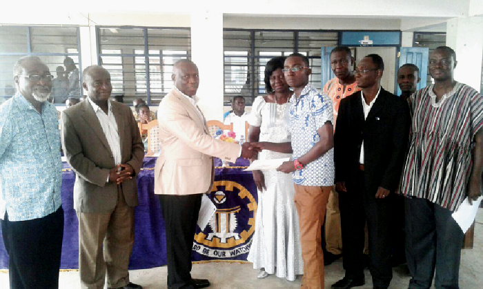 Prof. Edward Opoku Dapaah (third left) presenting the award to master Samuel Antwi while the headmistress, board chairman and other dignitaries look on