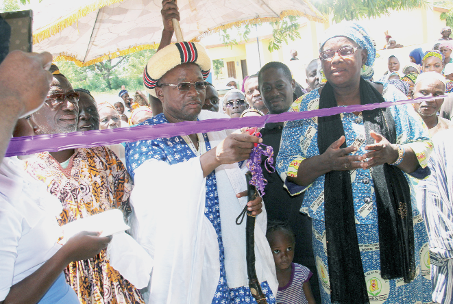  The Chief of Kasuliyili, Naa Yakubu Bukari (middle), cuts the tape to inaugurate the ward. (INSET) The front view of ward