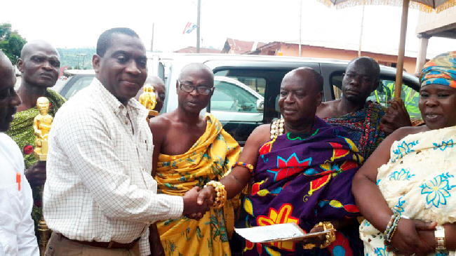 Mr Fred Nsarko (left), acting MD of AngloGold, presenting the documents covering the vehicle to the Adansihene, Nana Bonsra Afriyie