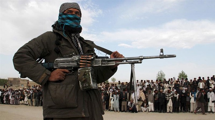 A Taliban fighter stands at the site of a public execution of three men in Ghazni province in 2015 [Reuters]