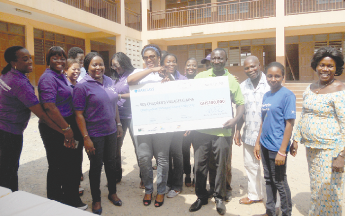   Mr George Boateng  (3rd right ), the  Programme Manager of SOS, receiving the cheque for GH¢100,000  from Mrs Pearl Esua Mensah (4th left ), Executive Council member, Executive Women Networt . Picture: ESTHER ADJEI