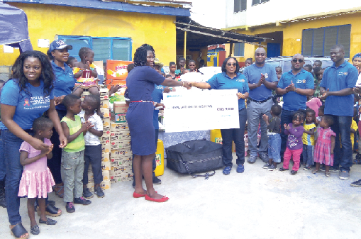 Mrs Ellen Ohene Afoakwa (right) making a presentation to Mrs Naomi Esi Amoah (left), Founder of Royal Seed Home/School, Bawjiase