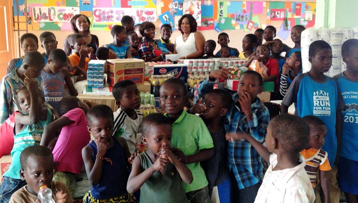 Mrs Ruth Rubabatu Agbesi, the CEO, Rubatch Enterprise, presenting the items to Ms Mariam Sagoe, Assistant Administrator of the Save Them Young Orphanage. Looking on are some of the inmates of the orphanage.