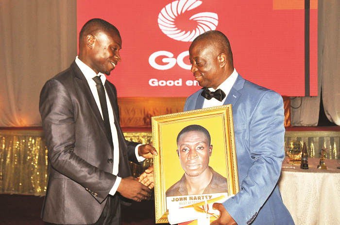 Mr John Nartey (left) receiving the best fuel attendant award from a management staff of GOIL