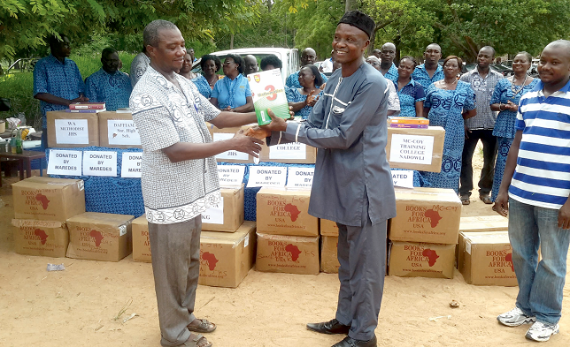 Mr Vincent Pugun (left) presenting the books to Mr Simon Yeng Bonsodong at the ceremony 