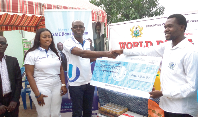 Mr Kwasi Nimako (2nd left) presenting a dummy cheque to the Director of DAFAREC, Mr Emmanuel Agyapong (right). With them is Mrs Victoria Esinam Assah Offei of NACOB