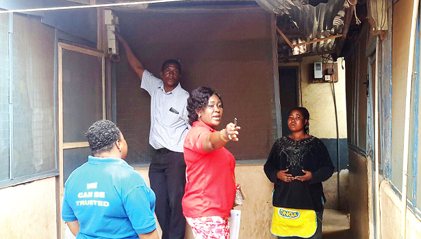 Ms Rosemond Asamoah Frimpong explaining to a customer (right) why her premises were being disconnected while an official of the Loss Control Unit disconnects the meter 