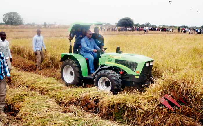 President Mahama driving one of the tractors to harvest a rice farm at Akuse in the Eastern region.