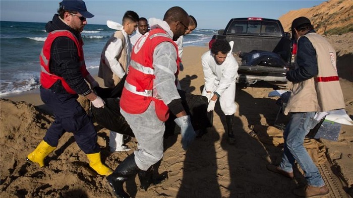File photo from 20 March shows Libyan Red Crescent workers recovering bodies of drowned migrants from a beach east of the city of Tripoli, Libya.