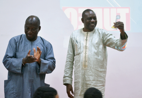  Dr Pelpuo admiring his award while a guest applauds him 