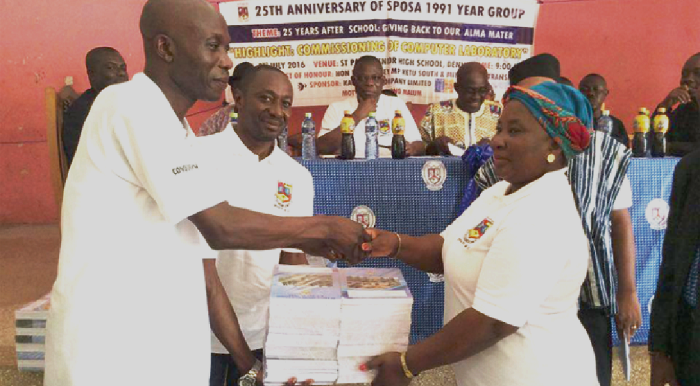 The Vice President of the year group, Mr Daniel Amehoe (left), presenting books to the Assistant Headmistress (Academic), Madam Alice Tanyedzi